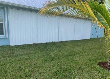 White accordion hurricane shutters along a house